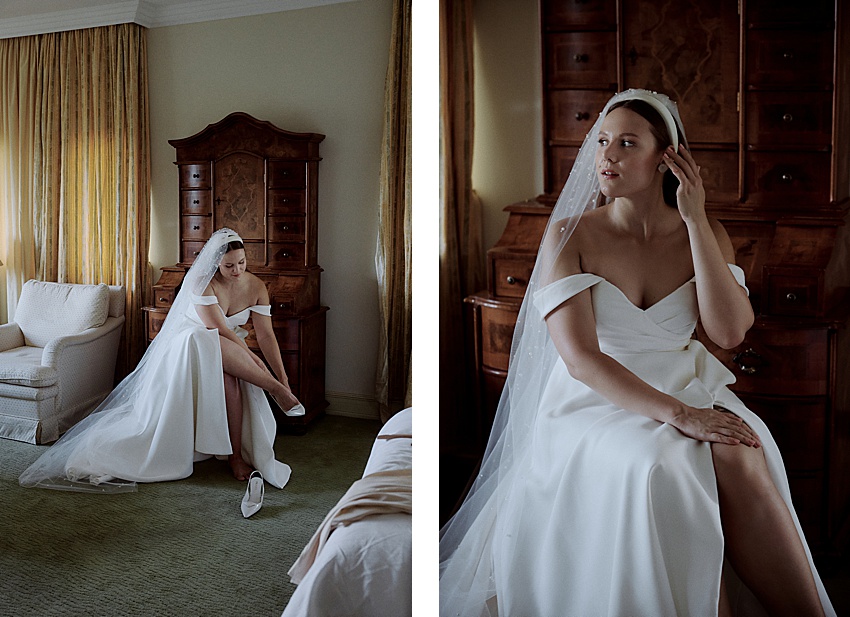 In einem Zimmer im Hotel Kaiserhof sitzt links eine Braut in einem schulterfreien weißen Kleid und Schleier, zieht Schuhe an und rückt rechts ihren Ohrring zurecht. Der Raum, der an eine Hochzeit in Hannover erinnert, besticht durch eine hohe Holzkommode und gelbe Vorhänge.